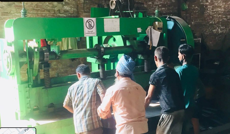 Amrit Enterprises team operating a sheet shearing machine